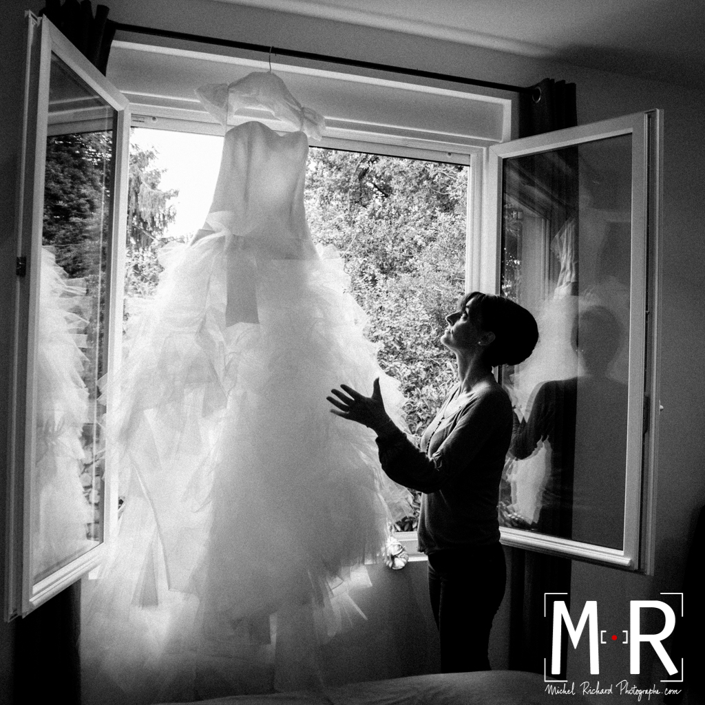 Mariage-preparatifs-La mariée regarde sa robe à la fenêtre-Michel-Richard