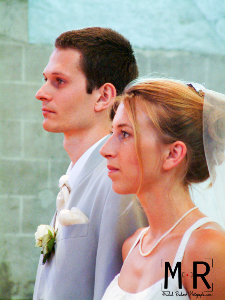 les mariés sont beaux et solennels lors de leur cérémonie de mariage à l'église pour la messe.