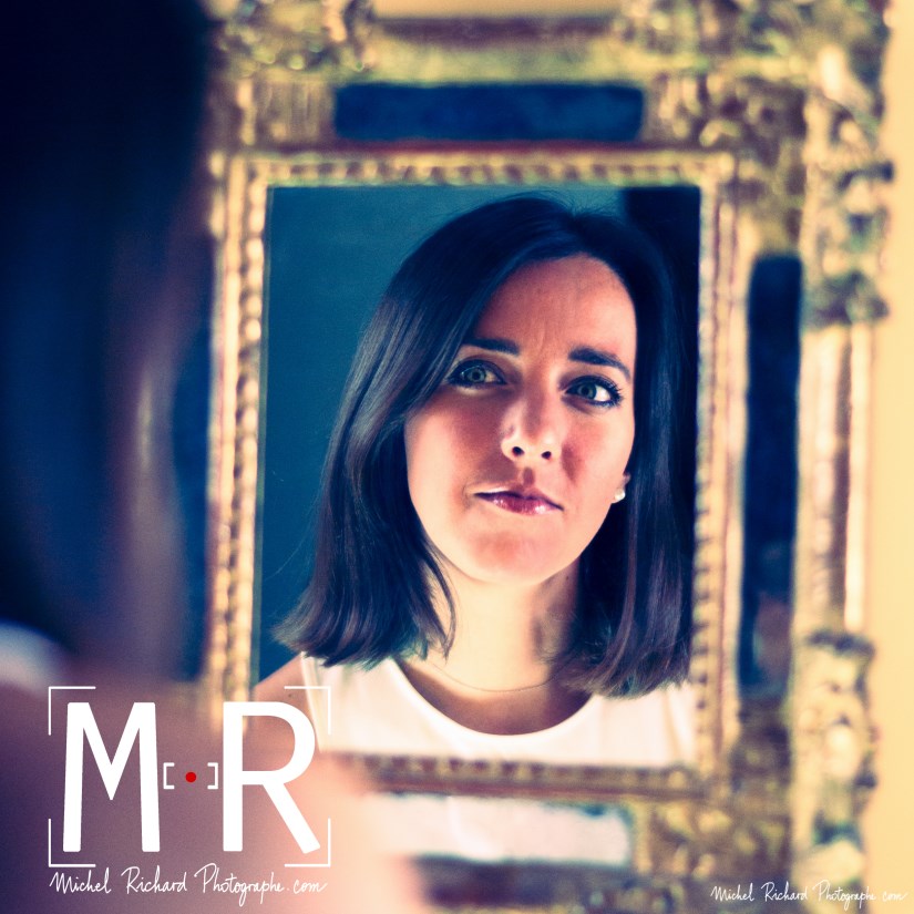 une jeune femme se contemple dans un miroir ancien