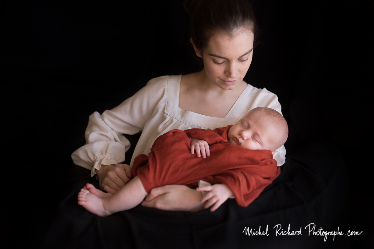 maman tregarde bébé endormi dans ses bras. séance photo studio